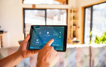 Unrecognisable man using tablet with smart home control functions at home.